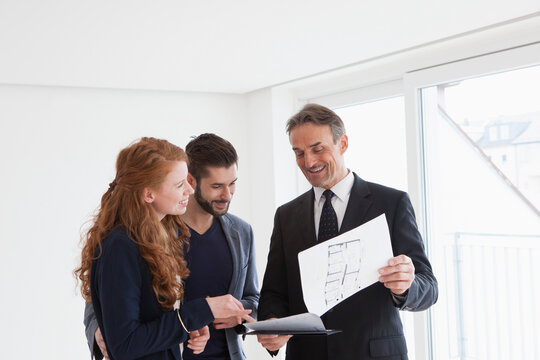 Young couple viewing flat with estate agent