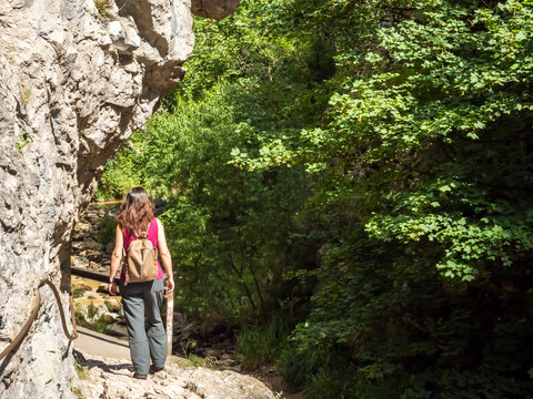 Female hiker walking along limestone trail in Turda Gorge