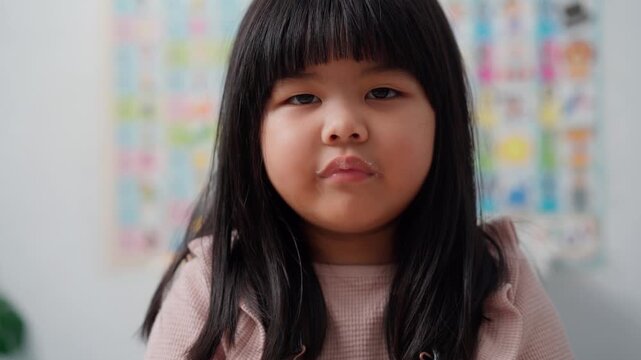 Asian Preschool Girl Drinking Fresh Milk During Healthy Breakfast
