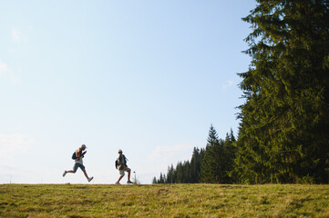Fototapeta premium Tourists hiking in the mountains on sunny day