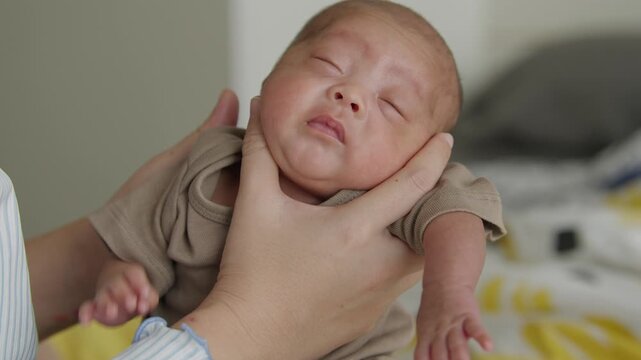 A mother's hands gently holding a newborn baby upright to burp after a full feeding, helping reduce reflux and prevent spit-up, infant care and parenting concept