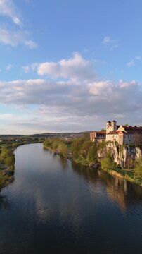 Aerial flyover of an abbey on a river in Poland at sunset in spring