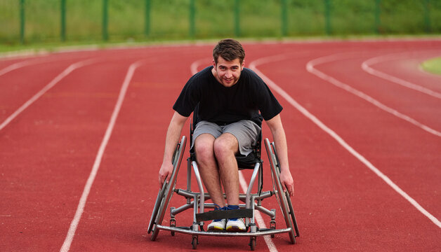 Male Wheelchair Athlete Racing on Outdoor Track, Smiling and Determined in Adaptive Sports