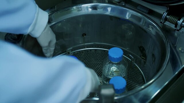 Scientist Reaching into Autoclave Chamber