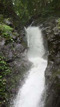 [スロー]岩肌を流れ落ちる滝　マイナスイオンなどの日本の自然のイメージ縦動画