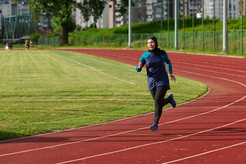 Obraz premium Woman in Hijab Running on Outdoor Track in Modest Sportswear Training for Fitness and Endurance