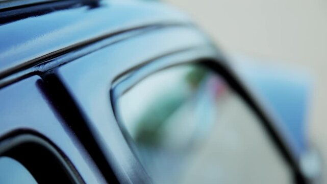 Extreme close-up shot capturing rapid vibration of car door frame, caused by powerful subwoofer bass frequencies. Visible shaking and distortion highlight impact of high-volume car audio system.