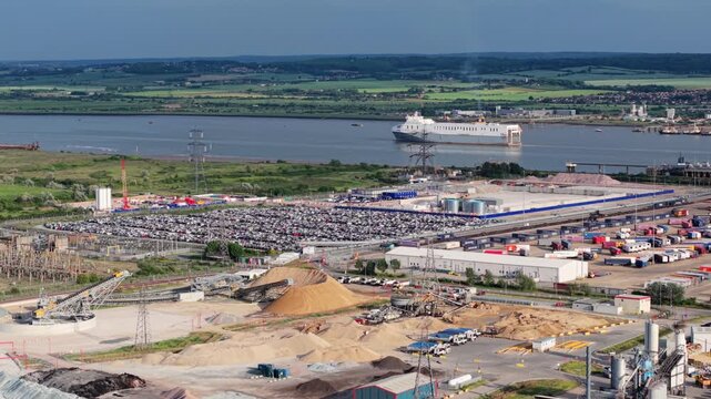Aerial view of large transport freight ferry departing River Thames past industrial port in Essex