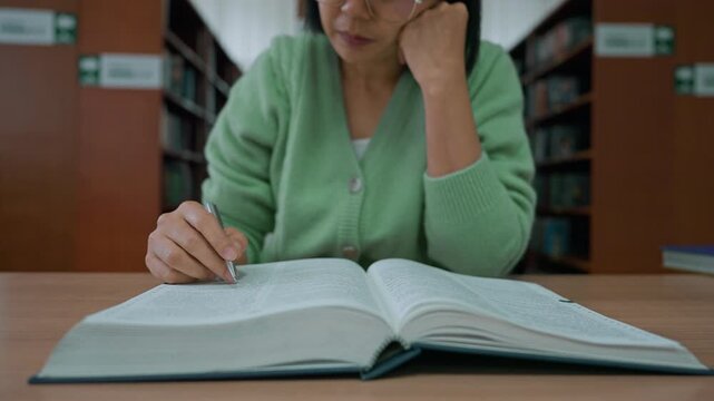 Close-up hand's woman reading book in library.
