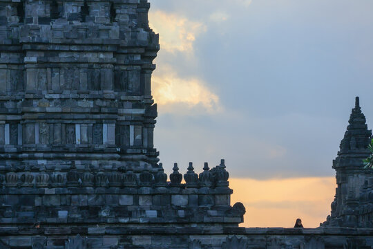 Ancient stone temple rises against soft sky. Carved tiers form a majestic, intricate spire. Details show ancient craftsmanship and spiritual devotion