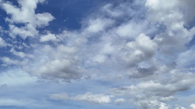 Cielo con nuvole bianche sparse in movimento su un fondale azzurro, con variazioni di luce e forme che cambiano lentamente. Atmosfera ariosa, luminosa e naturale