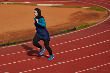 Obraz premium Woman in Hijab Running on Outdoor Track Training for Fitness and Endurance