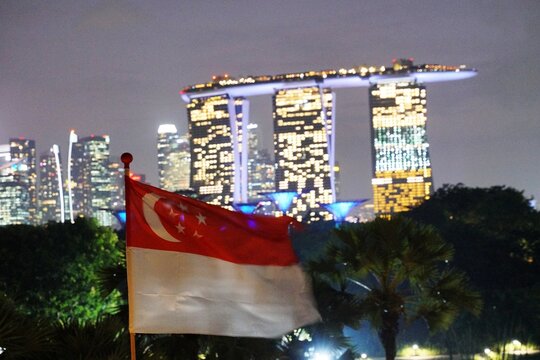 Singapore National Day celebration concept with waving state flag and Marina Bay Sands