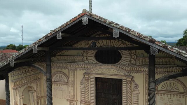 Aerial rises to cross on Immaculate Conception church in Bolivian town