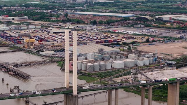 The Queen Elizabeth II bridge spanning River Thames near Dartford with industrial sites on banks, aerial view, UK.