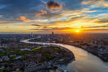 Naklejka premium Wide panoramic sunset view of the London skyline in England with Thames River leading with its curved stream into the City