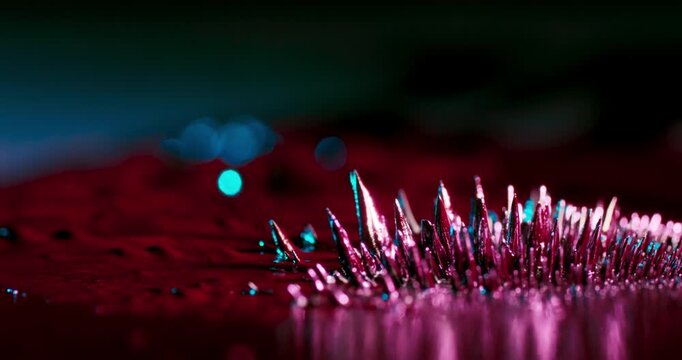 Experience captivating footage of metallic particles influenced by powerful magnetic forces on a dark background. Its ideal for enhancing motion graphics and design projects with intriguing visuals