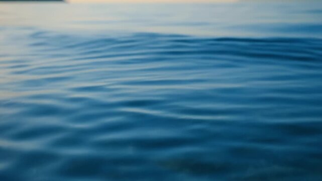 Calm blue water surface with gentle ripple wave and liquid reflection creating peaceful soothing nature scene perfect for relaxation and tranquil outdoor environment