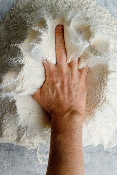 The pizza maker's hand accidentally lands on the flour and makes an obscene gesture with the middle finger raised. Joke, humor, coincidence