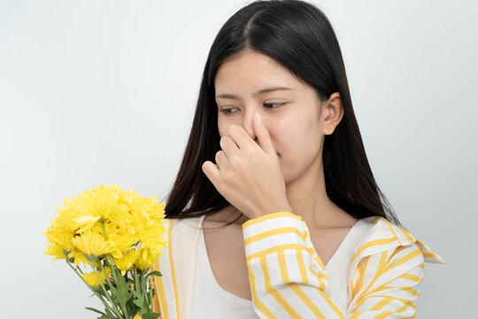 Pollen Allergies, asian young woman sneezing in a handkerchief or blowing in a wipe, allergic to wild spring flowers or blossoms during spring. allergic reaction, respiratory system problems