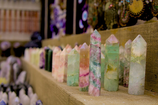 Row of colorful, faceted crystal points rests on rustic burlap