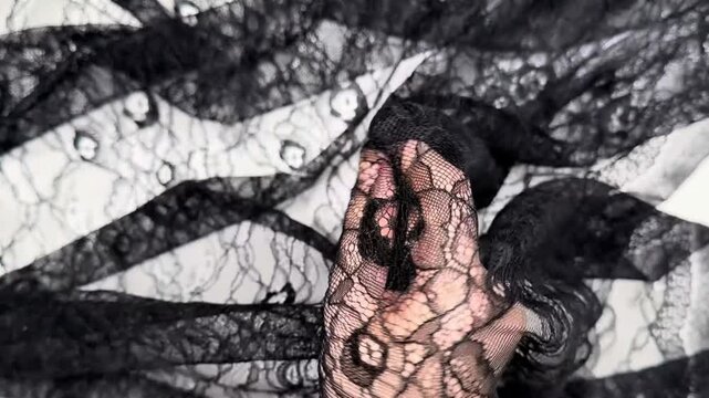 Black stretch lace fabric featuring a delicate floral pattern on soft mesh background suitable for apparel design and elegant garment manufacturing with detailed texture shown closely.