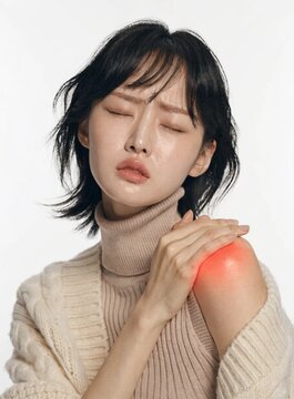 A young woman with a painful facial expression winces while clutching her aching shoulder, which features a prominent red glow effect to highlight localized joint and muscle inflammation 