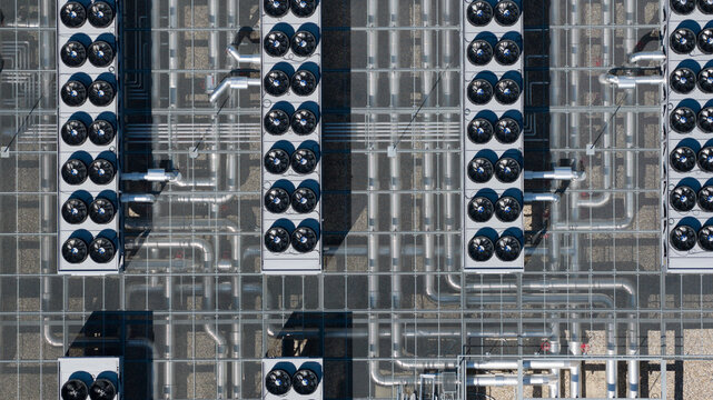 Aerial view of the industrial cooling systems and piping at Switch Datacenters AMS4 with rows of fans on the rooftop in Diemen, Noord-Holland, Netherlands.