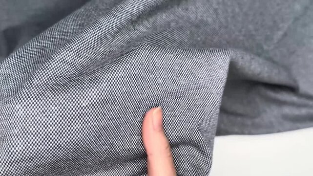 Close view of gray mesh textile featuring a fine open weave, transparent structure and soft folds. The lightweight material displays delicate texture and airy drape suitable for apparel and decorative