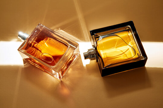 Luxury gourmand perfume bottles reflecting elegant warm light