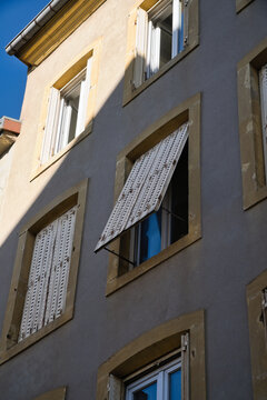 Mediterranean house facade with outward-opening shutters.
