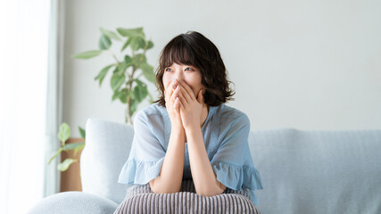 Fototapeta premium ソファでリラックスする笑顔の女性, Smiling Woman Relaxing on a Sofa