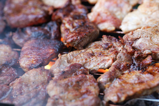 Zubereitung von Schweinefleisch auf einem Holzkohlegrill