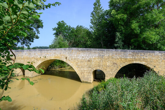 Vieux pont de pierre dans le Tarn, sur un ruisseau marron  charg&eacute; en s&eacute;diments