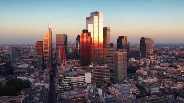 Aerial view of the City of London, England, skyline with office skyscrapers reflecting the golden sunlight during sunset