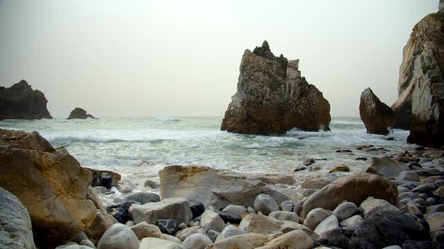 Beautiful rocky coast on the Atlantic coast. The famous Portuguese Ursa Beach. Beautiful panorama of the Rocky shore with incoming turquoise waves. Beautiful seascape on the background of rocks.