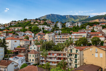 Fototapeta premium Charming stone houses with red tiled roofs built along the scenic coastal hills of Herceg Novi