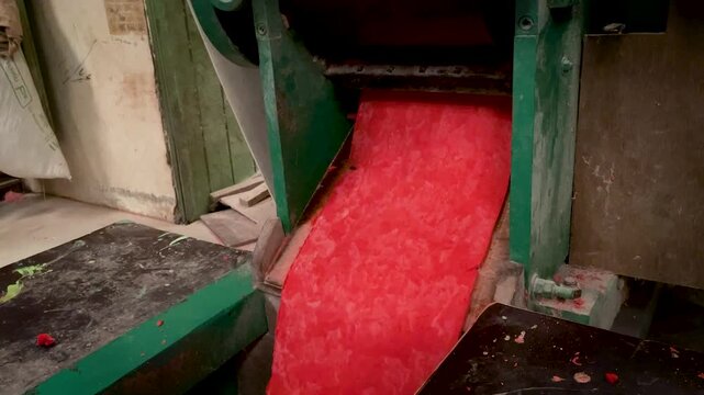 Red Noodle Dough Sheet Coming Out of Traditional Press Machine in Mie Habang Workshop South Kalimantan Indonesia