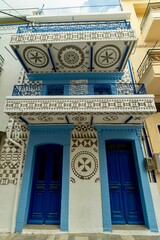Naklejka premium Chios, Greece - May 24, 2026: Scenic street view of Pyrgi village on Chios Island, Greece, featuring traditional decorated houses, narrow lanes, stone buildings, and the unique medieval architecture o