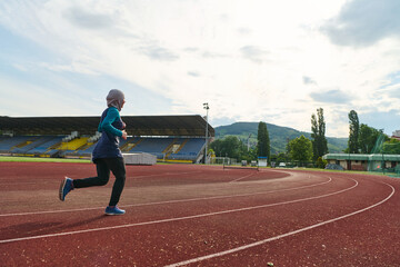 Fototapeta premium Muslim Woman In Hijab Running On Outdoor Track At Empty Stadium For Fitness Training
