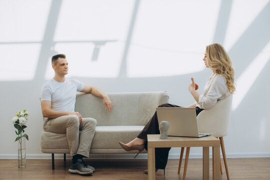 Psychologist counseling male patient during therapy session