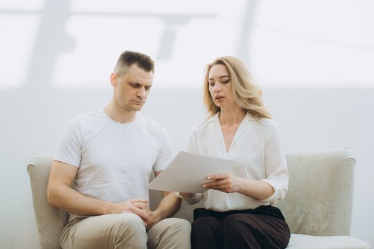 Psychologist explaining document to male patient during session