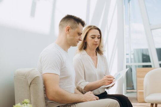 Psychologist counseling male patient during therapy session