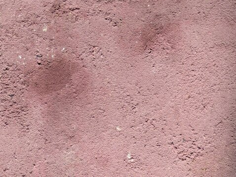 Close-up of fine pink sand with natural granular texture and soft earthy tones, ideal for abstract backgrounds, design projects, and surface studies.