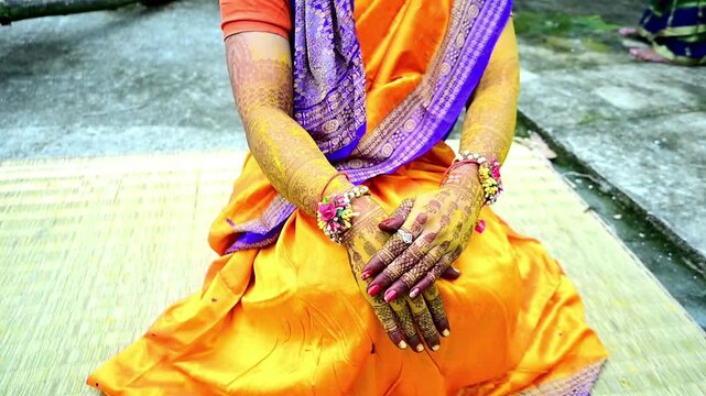 Close-up footage of a traditional Indian Haldi ceremony where family members and friends apply turmeric paste to the bride before marriage. The pre-wedding ritual symbolizes purification, blessings.