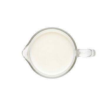 Top view of fresh milk in a glass pitcher on white background