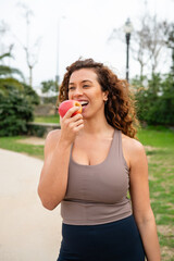 Fototapeta premium Healthy woman eating fresh apple for nutrition in park