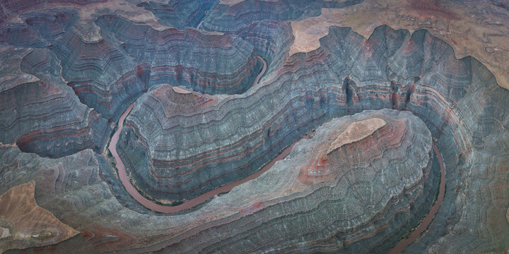 Aerial view of the winding San Juan River flowing through deep layered rock canyons and geological formations in Mexican Hat, Utah, United States.