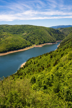High angle aerial view of the famous Uvac River meanders canyon in Serbia. Stunning drone landscape of curvy river flowing through deep rocky cliffs and green hills.