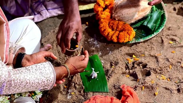 Close-up footage of a traditional Hindu wedding ceremony showing sacred marriage rituals performed by the bride, groom, family members, and priest. The ceremony includes religious customs